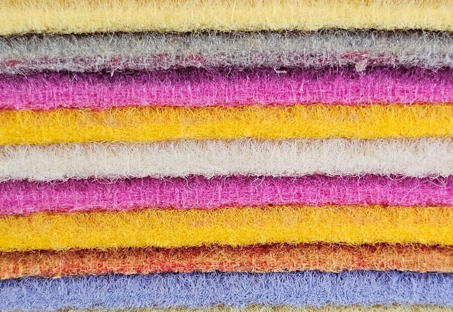 Close-up view of layered colorful textile fabrics in vibrant shades.
